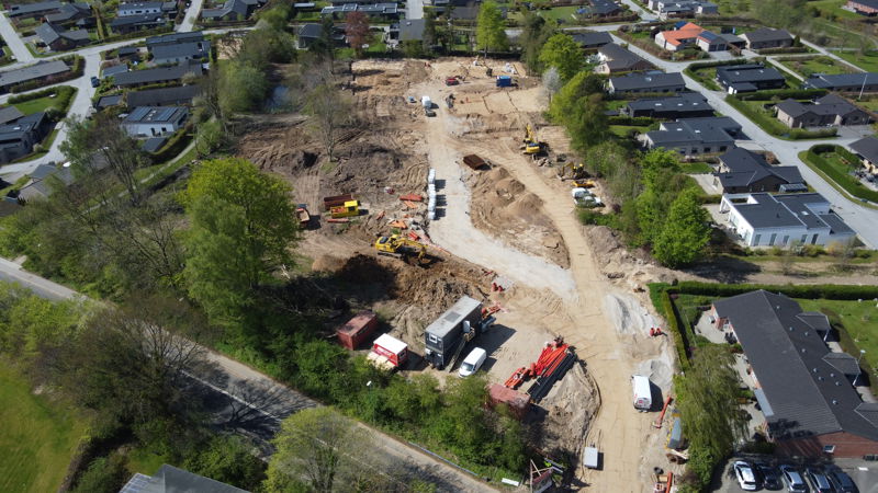 Dronefoto af byggeplads med maskiner, der laver sandpude på et rækkehusprojekt